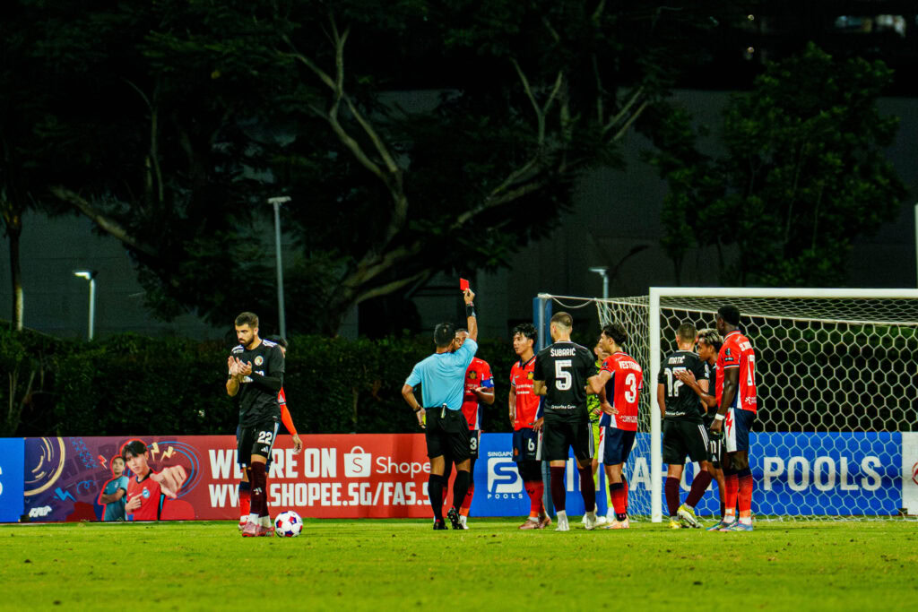 Youth soccer players practicing free kick during training session at the field.