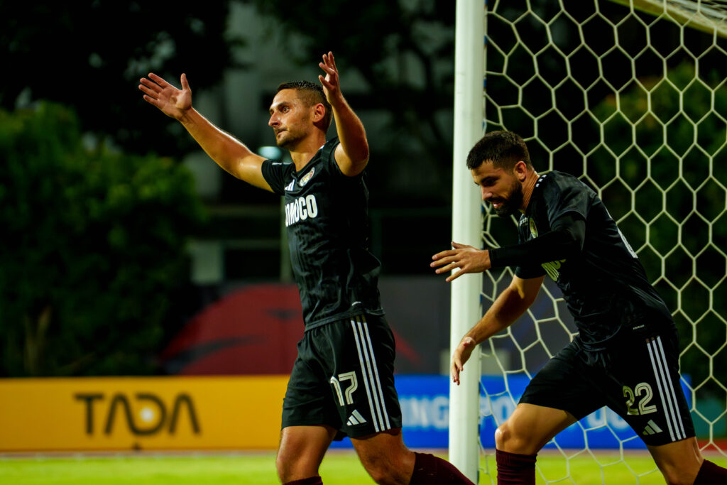 Soccer players celebrating a goal on the field during a match.