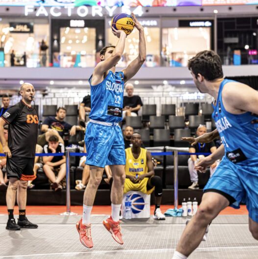 Basketball player shooting during a game at baseline.sg.